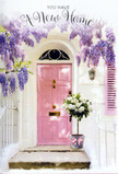 This image shows a calm, storybook-like doorway in Surbiton, styled to celebrate the hopeful moment when someone first crosses into a new home. A front door painted in a soft, powder-pink shade stands in the centre, its finish satin and gently worn, suggesting character rather than gloss. It is set into a backdrop of whitewashed walls that lend brightness and simplicity, similar to the light facades you might spot along the residential streets branching from Maple Road. Draping down from above, wisteria spills in luxuriant clusters, its blooms shaded from deeper lavender at the top to paler lilac at the tips. The flower racemes hang in overlapping layers, creating a delicate canopy that frames the entrance with colour and soft shadow. On the doorstep, a grey metal bucket takes on a new role as a rustic vase, filled completely with creamy white and ivory roses. Each rose is captured mid-bloom, petals full and rounded, some still cupped at the centre while others open more freely, creating texture and depth. Here and there, clusters of soft, dusty green foliage break up the white, making the bouquet feel fresh and natural, as if it had just been gathered from a Surbiton garden. Around the bucket's base, a satin ribbon in gentle blush-pink is tied in a simple, elegant bow; its sheen and colour echo the door, pulling the whole palette together. The light is easy and natural, suggesting a mild afternoon, with small, soft-edged shadows at the base of the bucket and underneath the wisteria. It's a scene that suggests a new home flower delivery placed thoughtfully at the door - a quiet, fragrant blessing for the life that is about to unfold inside this Surbiton home.